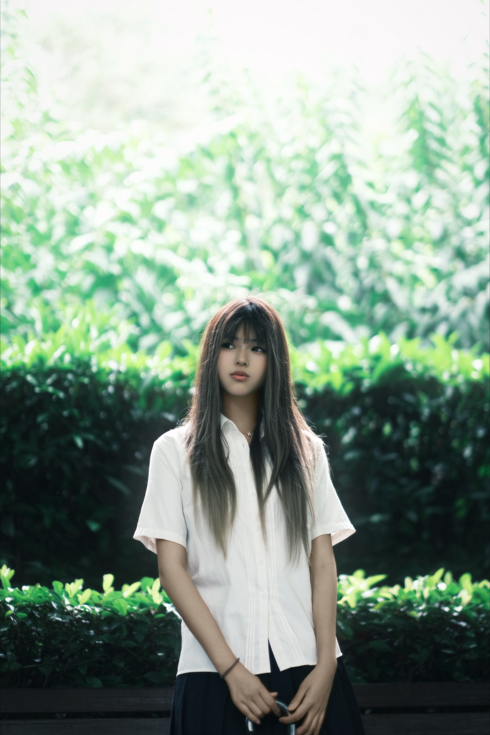 Portrait of Angel Xiao standing in a sunlit garden